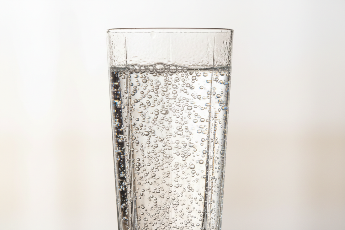 Sparkling carbonated water with bubbles in glass showing effervescence and clarity